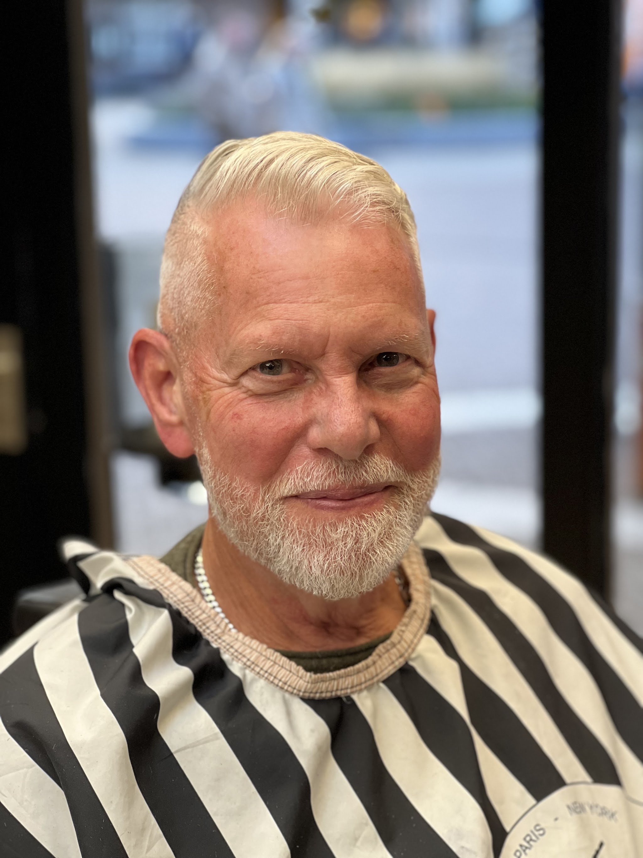 Oudere heer met een witte fade en baard in de kappersstoel bij Kapsalon Gold Style